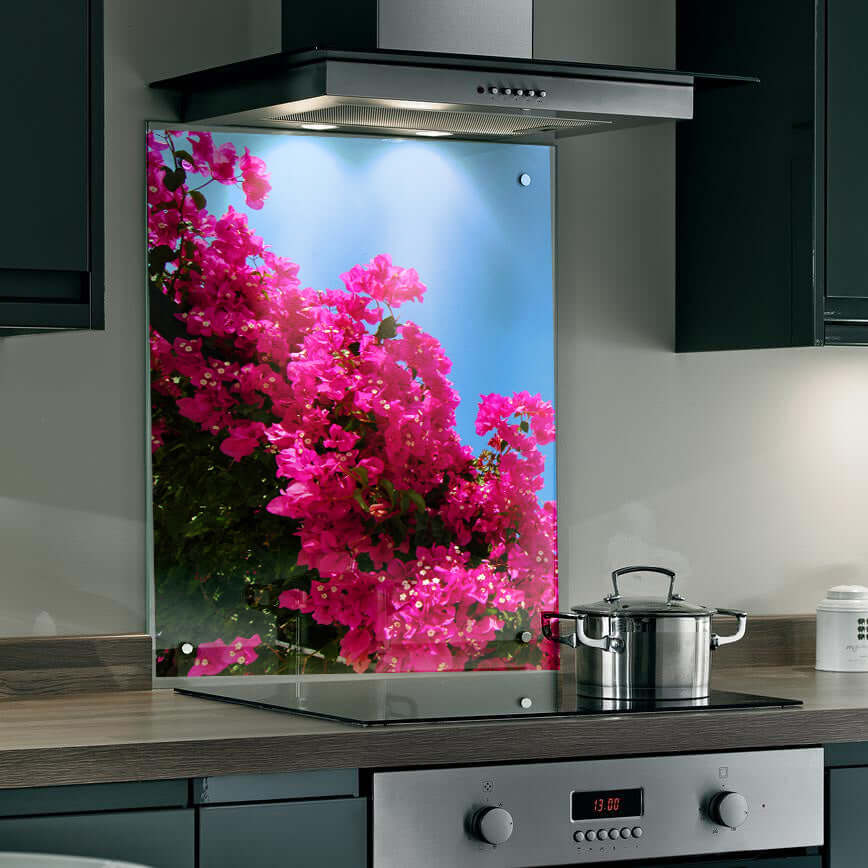 Vibrant bougainvillea splashback with bold pink blooms against a clear blue sky in a modern kitchen.