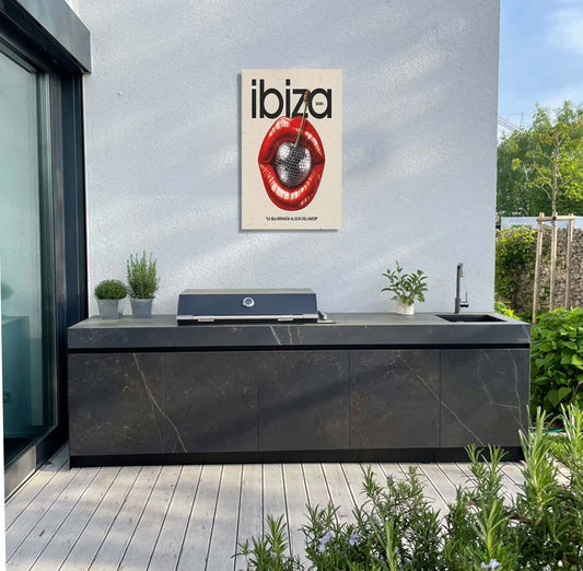 Ibiza Lips garden art displayed above a modern black outdoor kitchen on a sunny patio.