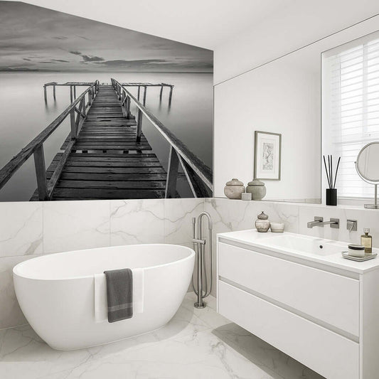 Black and white photo of a jetty over a calm river, enhancing a modern bathroom with a tranquil atmosphere.
