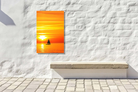 Sunset Sail artwork on a white wall, featuring a golden sunset and sailboat over an ocean horizon.