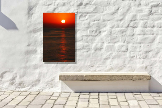 Crimson Dusk artwork features a deep red sunset over calm waters, enhancing outdoor spaces with warmth and serenity.